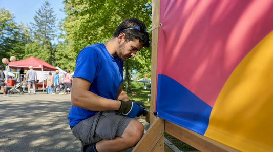 Technician unrolling vinyl banner outside event